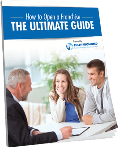 Three people sit at a table, one with a booklet titled "How to Open a Franchise: The Ultimate Guide" by Fully Promoted.